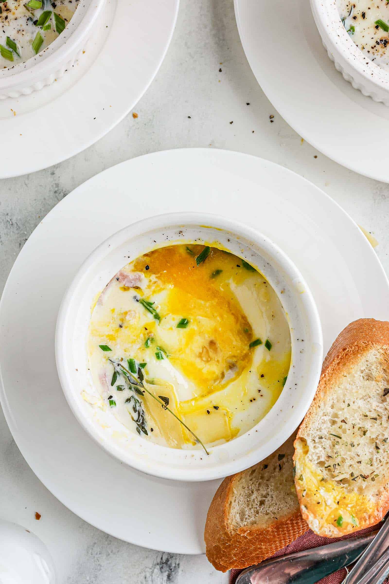Eggs en Cocotte served on a plate with bread.