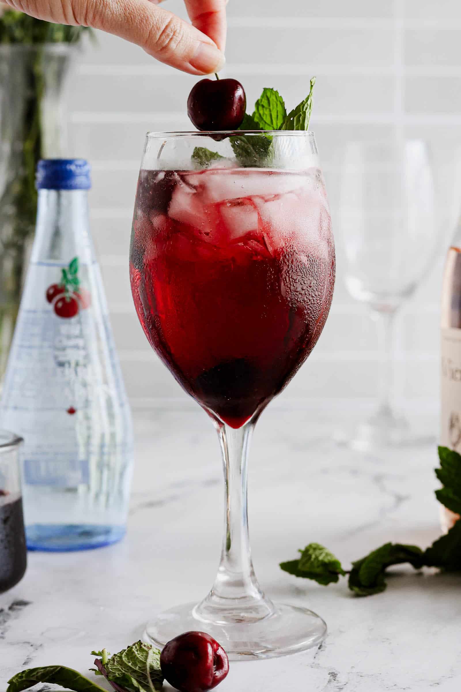 Cherry & Mint Wine Spritzer with a cherry being placed on top