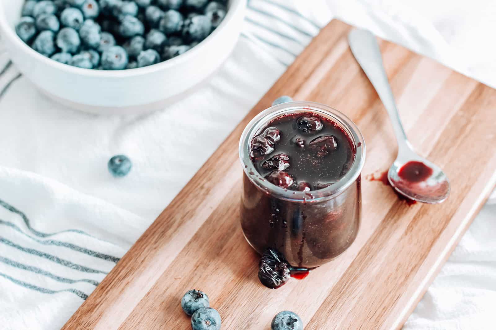 Blueberry lemon compote in a jar on a serving board.