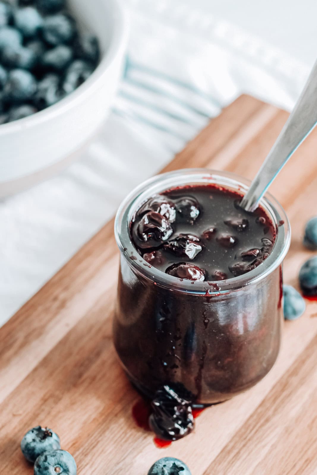 Blueberry lemon compote in a jar on a serving board.