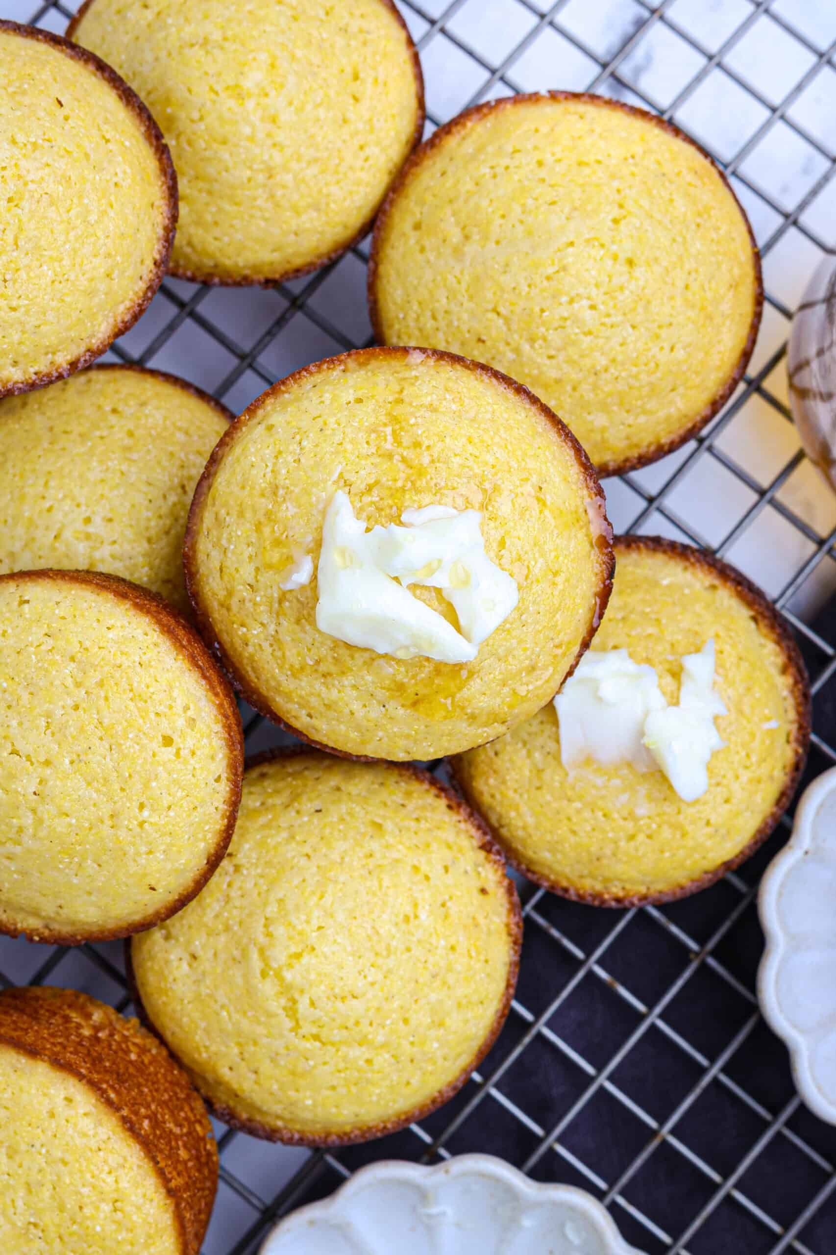 Honey cornbread muffins with butter on top.