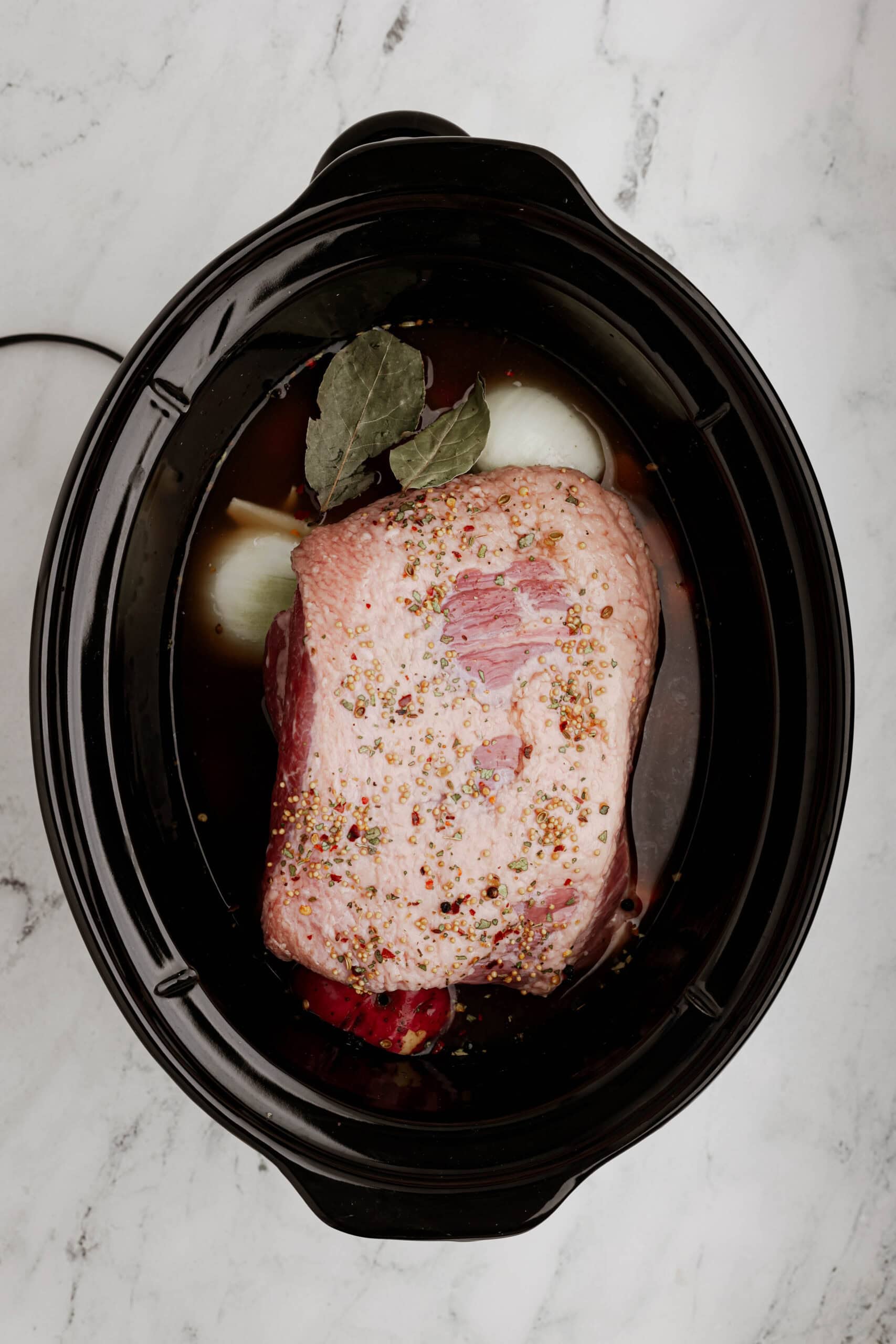 Add corned beef and liquid to the slow cooker.