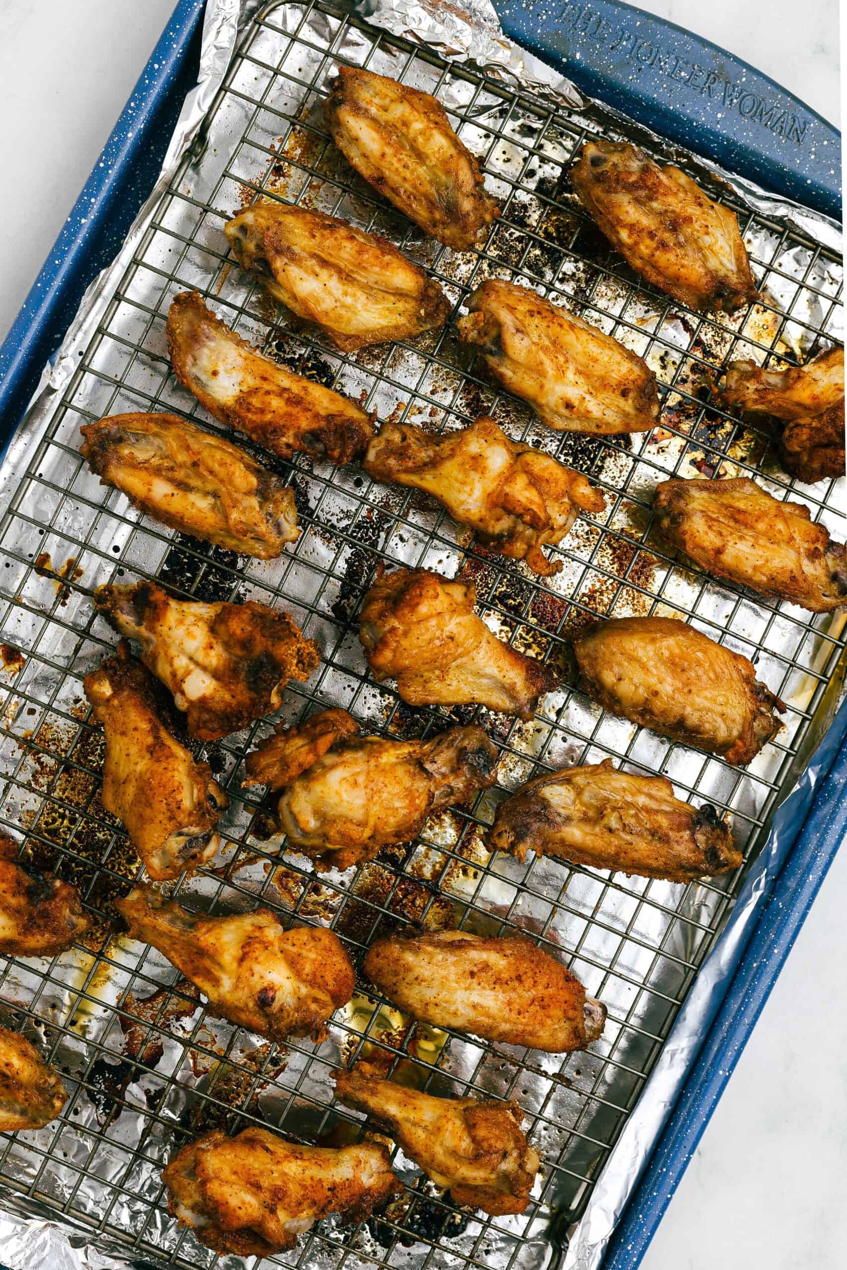 Baked crispy chicken wings on a wire rack just out of the oven, golden and lightly browned