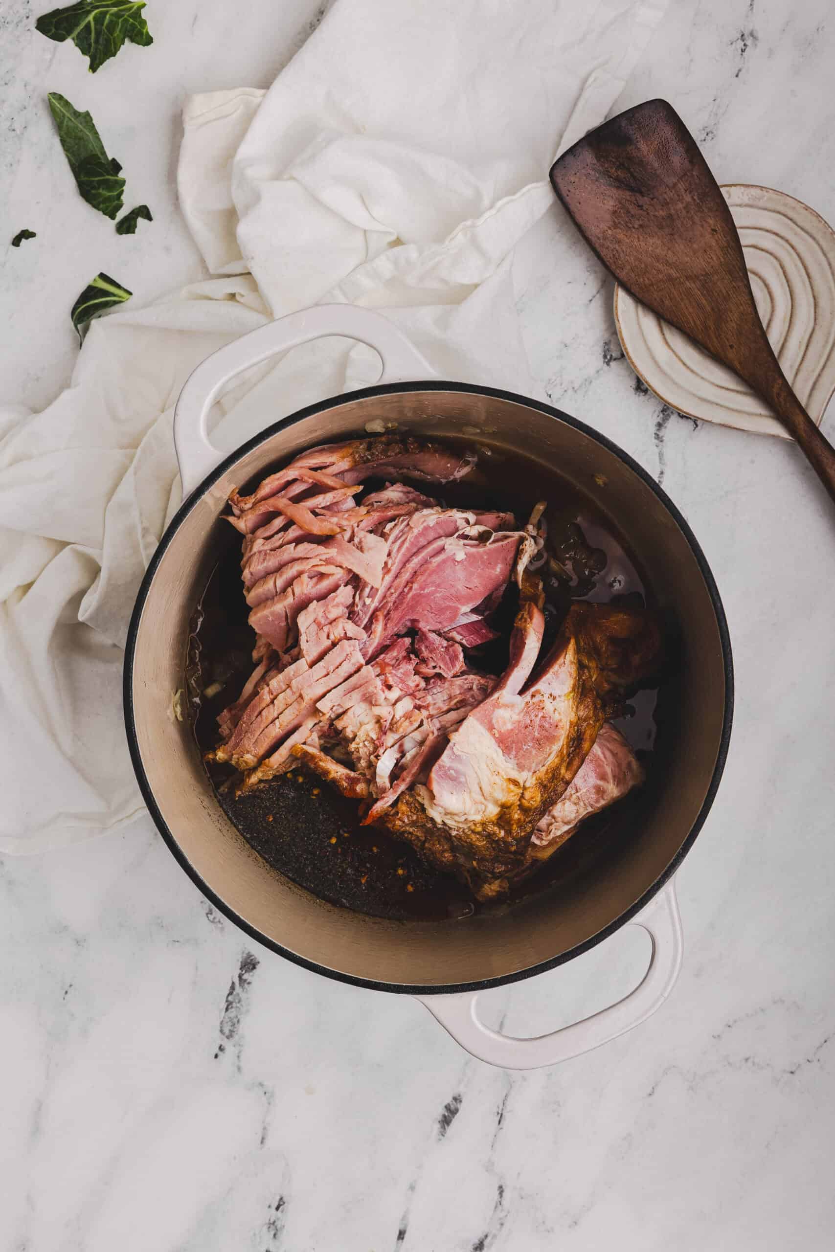 Ham bone and broth added to the pot to season collard greens.