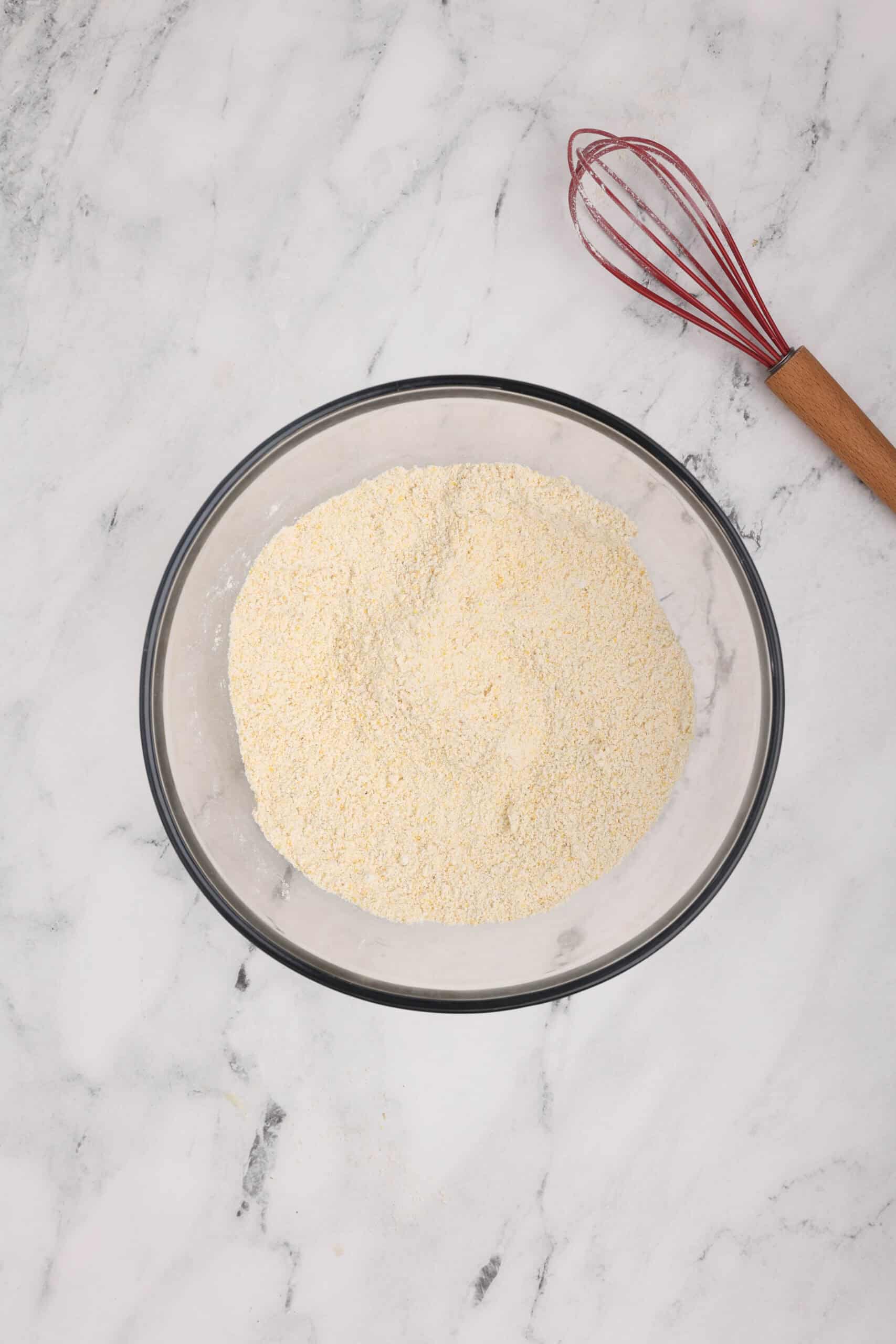 Dry ingredients for cornbread whisked together in a large mixing bowl.