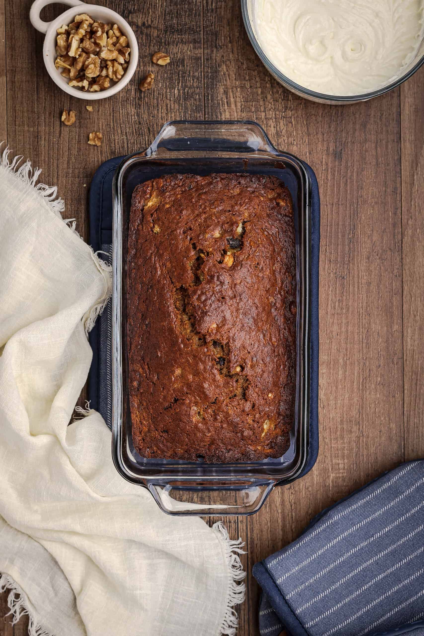 Freshly baked carrot cake banana bread in a glass loaf pan with golden brown top