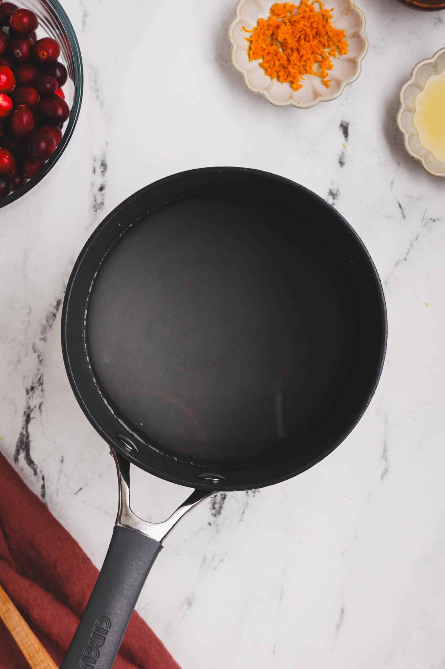 Water in a saucepan ready to be heated for making cranberry orange sauce.