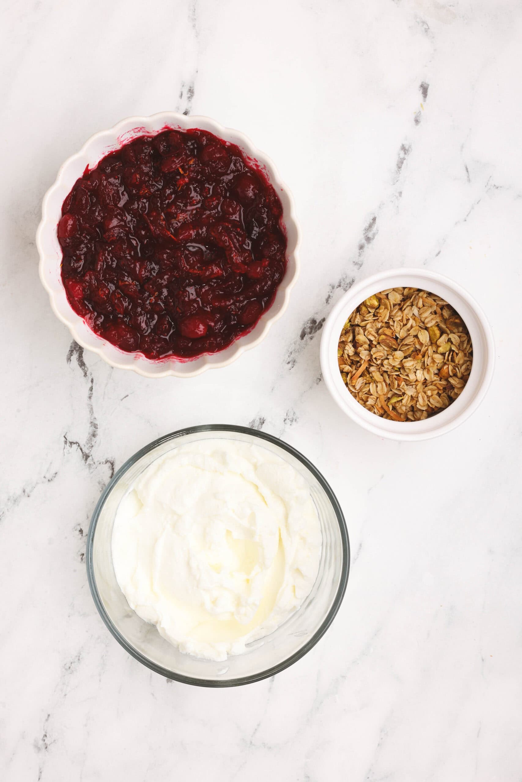 Cranberry parfaits ingredients on a white surface.
