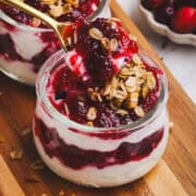 Delicious cranberry sauce layered with yogurt and granola in glass jars. Perfect for festive breakfa.