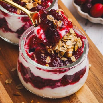 Delicious cranberry sauce layered with yogurt and granola in glass jars. Perfect for festive breakfa.