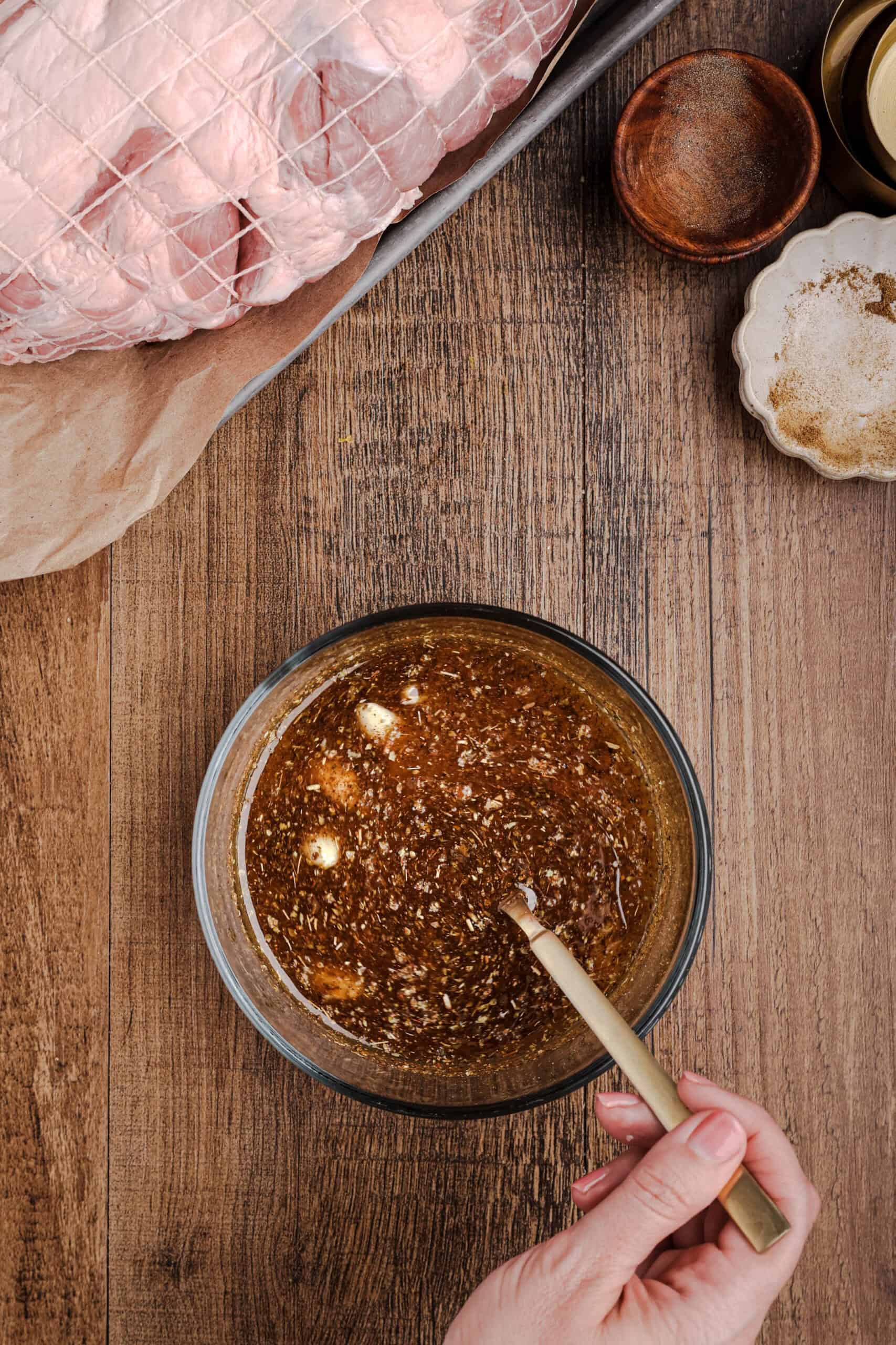 Homemade mojo marinade made with citrus juice, garlic, oregano, cumin, and olive oil being mixed in a glass bowl.