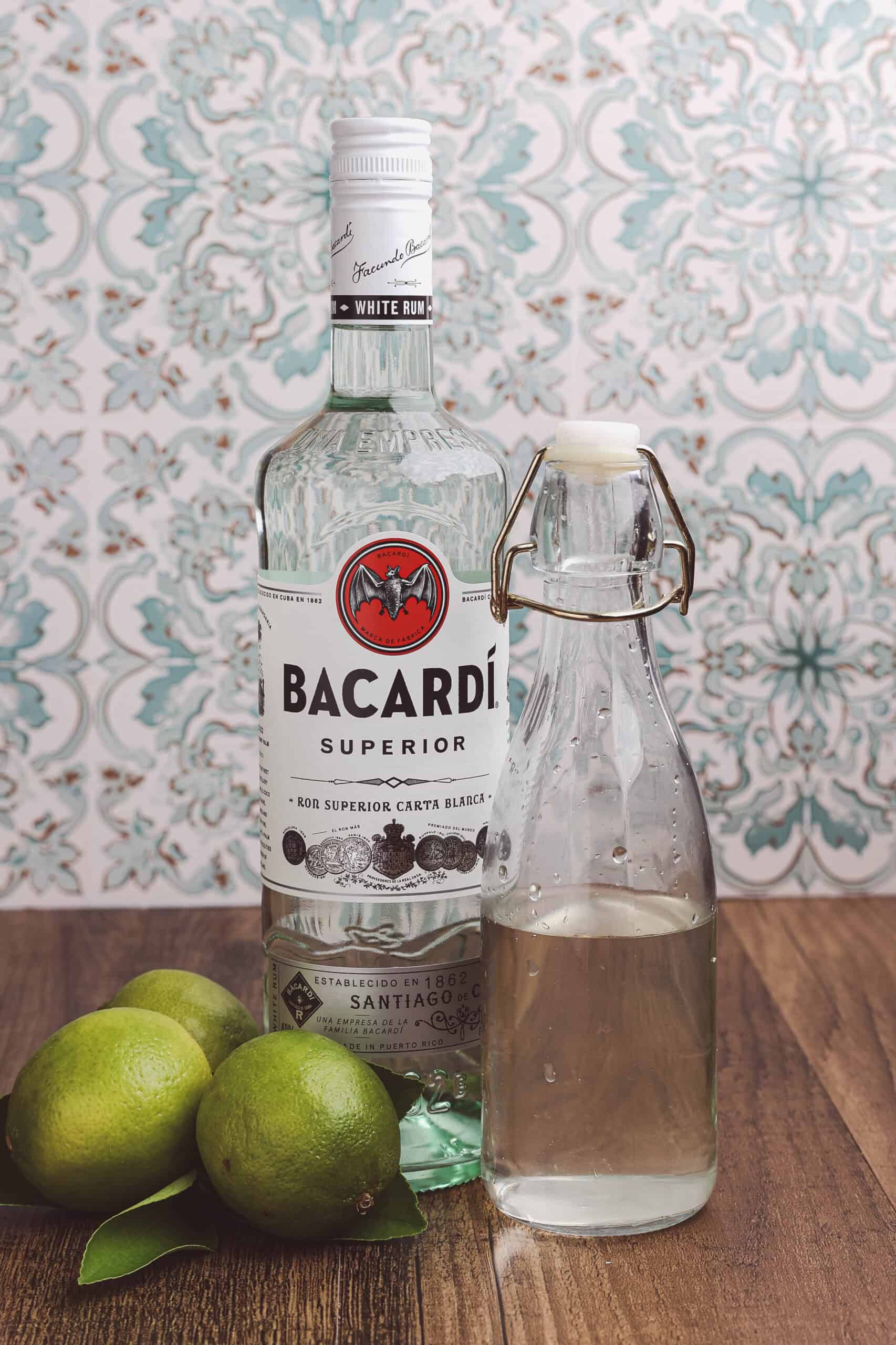 Ingredients for a classic daiquiri including white rum, simple syrup, and fresh Florida limes.