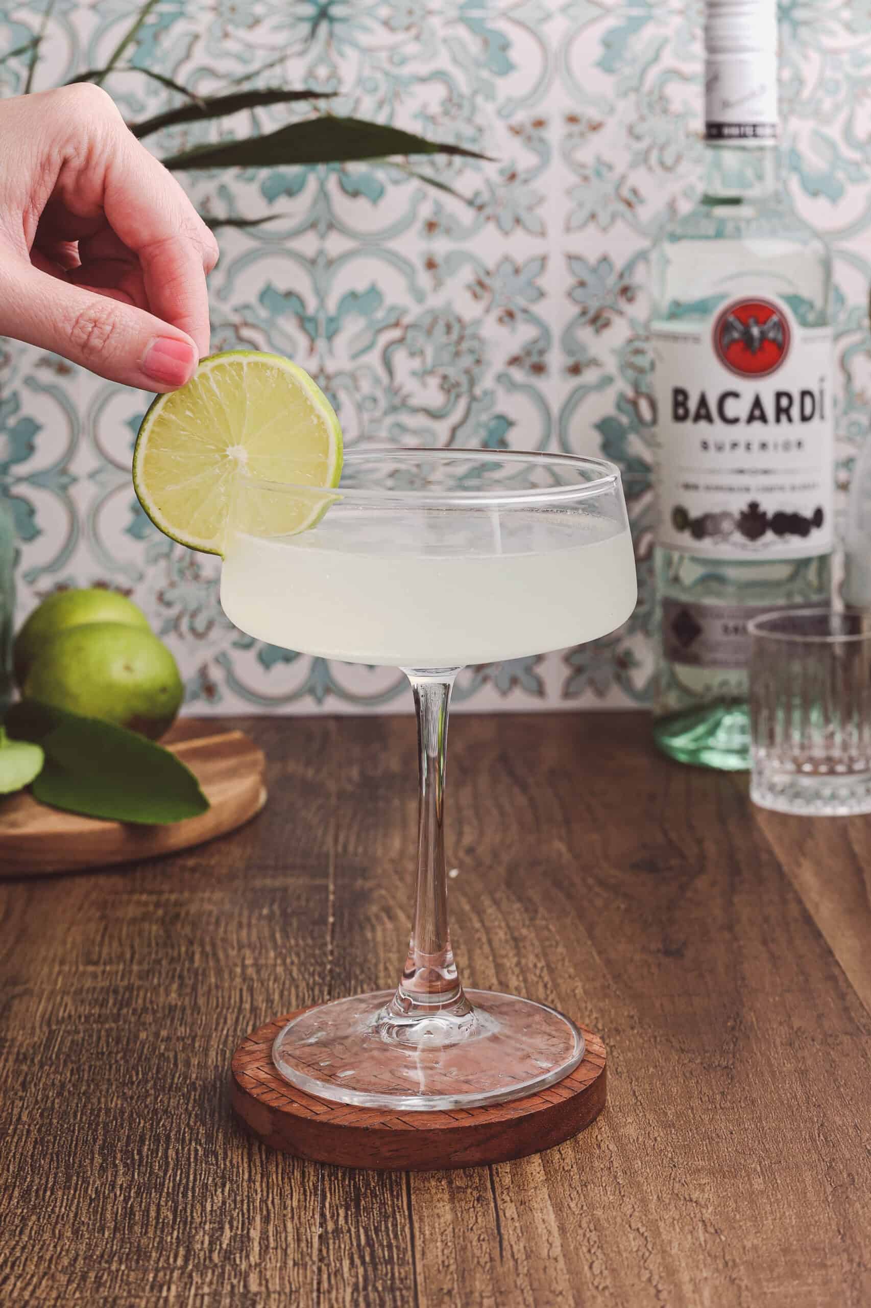 Garnishing a classic daiquiri with a fresh lime wheel before serving.